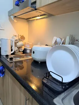a kitchen with a sink and a counter with dishes at City View Near MOA & NAIA with PS4, Wi-Fi, Netflix in Manila
