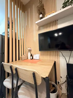 a wooden table with chairs and a television on a wall at City View Near MOA & NAIA with PS4, Wi-Fi, Netflix in Manila