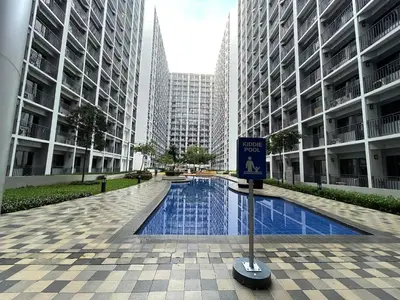 a swimming pool in a city with tall buildings at Cozy Haven Staycation in Manila