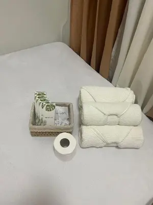 a table with towels and a tray of toilet paper at Cozy Haven Staycation in Manila