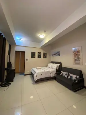 a bedroom with a bed and a couch in it at Alliyah staycation newport101 near naia terminal 3 in Manila