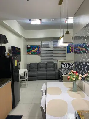 a kitchen and living room with a couch and a table at Alliyah staycation newport101 near naia terminal 3 in Manila