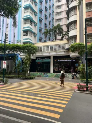 a person walking across a crosswalk in a city at Alliyah staycation newport101 near naia terminal 3 in Manila