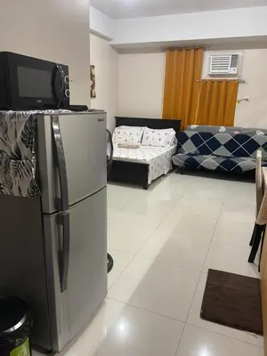 a living room with a refrigerator and a couch at Alliyah staycation newport101 near naia terminal 3 in Manila