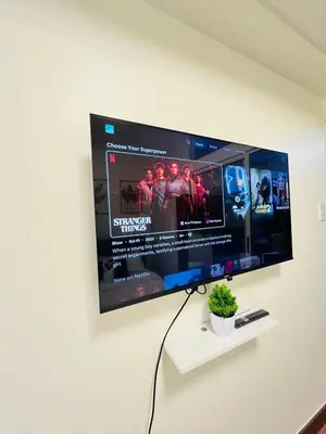 a flat screen tv hanging on a wall at Chill Escape Prisma near BGC and Ortigas in Manila