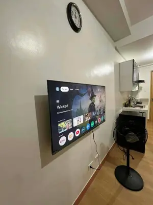 a flat screen tv hanging on a wall at Transient Home by Molave in Manila