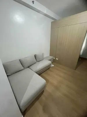 a living room with a couch and a wooden floor at Transient Home by Molave in Manila