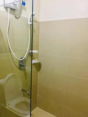 a shower with a glass door in a bathroom at Paseo Verde in Manila
