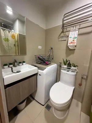 a bathroom with a white toilet and a sink at Shore Bliss Staycation by Aims in Manila
