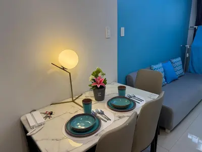 a dining room table with two plates and a lamp at RM A837 S Residence near SMX and SM Arena in Manila