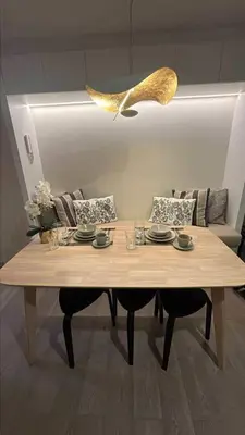 a wooden table with plates and glasses on top of it at InSpire Cozy Elegance in Makati City in Manila
