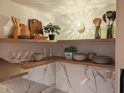 a kitchen with plates and glasses on a shelf at InSpire Cozy Elegance in Makati City in Manila