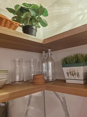 four glass bottles on a shelf with a potted plant at InSpire Cozy Elegance in Makati City in Manila
