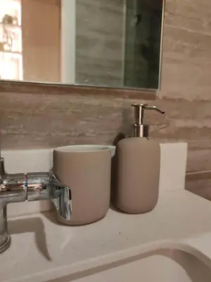 two white cups sitting on a bathroom sink at InSpire Cozy Elegance in Makati City in Manila