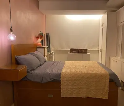 a bedroom with a bed and a light on the wall at Affordable, Cozy & Quiet 1BR in BGC - Ideal for Short & Long Stays in Manila