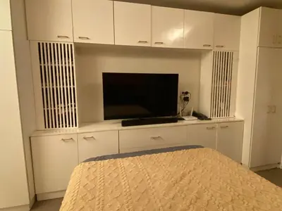 a bedroom with a tv in a white cabinet at Affordable, Cozy & Quiet 1BR in BGC - Ideal for Short & Long Stays in Manila