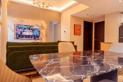 a living room with a table and a green couch at Premium Condo units at Gentry Manor beside Okada Manila and near Airport in Manila