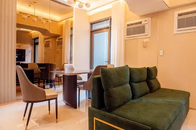 a living room with a couch and a dining room at Premium Condo units at Gentry Manor beside Okada Manila and near Airport in Manila