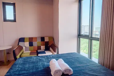 a bedroom with a bed and a chair with towels on it at Premium Condo units at Gentry Manor beside Okada Manila and near Airport in Manila