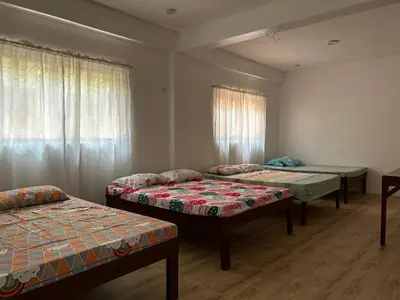 a room with three beds and a window at Jarens Diner in Silang