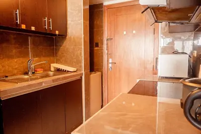 a small kitchen with a sink and a refrigerator at Elegant Condo at ETON Baypark Manila in Manila