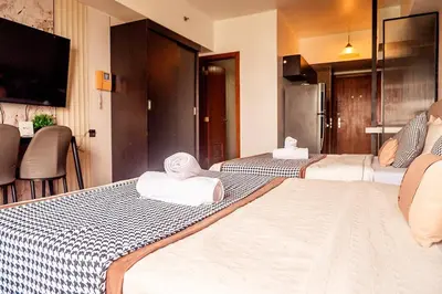 a hotel room with two beds with towels on them at Elegant Condo at ETON Baypark Manila in Manila