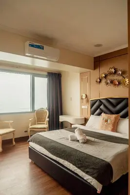 a bedroom with a large bed with a large window at Classic-style Top Floor In Manila Bay in Manila