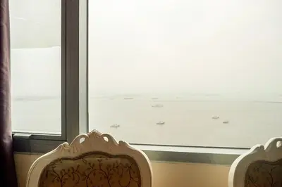 two chairs in front of a window with a view of the ocean at Classic-style Top Floor In Manila Bay in Manila