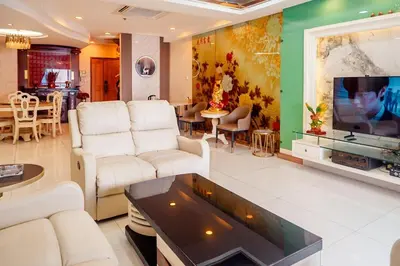 a living room with white furniture and a flat screen tv at Classic-style Top Floor In Manila Bay in Manila