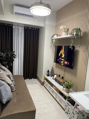 a living room with a fireplace on the wall at Shore Residence 3 Mall of Asia by Balai Selah in Manila