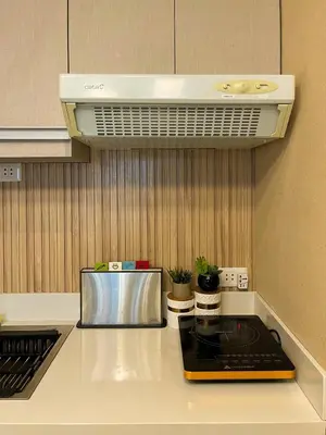 a kitchen with a counter with a stove top oven at Stylish & Serene Penthouse in Manila