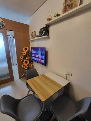 a meeting room with a wooden table and two chairs at Shell Residences Condo in Manila