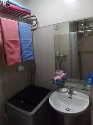 a bathroom with a sink and a toilet and a mirror at Shell Residences Condo in Manila