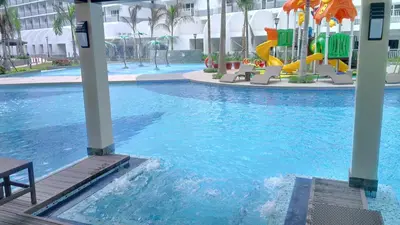 a swimming pool with a playground in a hotel at Shell Residences Condo in Manila
