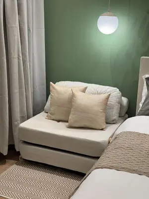 a room with two beds and a couch with pillows at Top-Floor Studio in Makati with City Views Good For 2-3 Pax in Manila