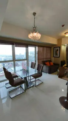 a living room with a glass table and chairs at Venice Condotel in Manila