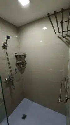 a bathroom with a shower with a basket on the wall at Venice Condotel in Manila