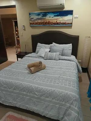 a bed with a towel sitting on top of it at Venice Condotel in Manila