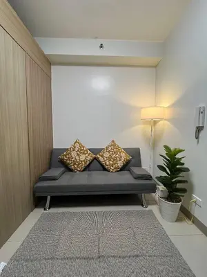 a couch in a living room with a lamp at Shore Residences in Pasay Manila, near Mall of Asia and Manila Airport in Manila