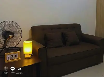 a living room with a couch and an alarm clock at Shore Residences in Pasay Manila, near Mall of Asia and Manila Airport in Manila