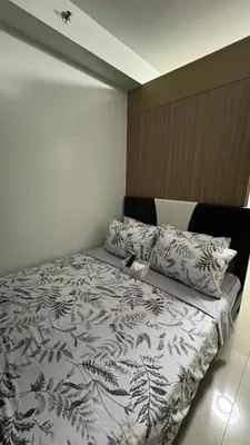 a bedroom with a bed with a black and white comforter at Mall of Asia Staycation, located in Shore Residences Pasay Manila near Manila Airport in Manila