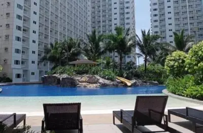 a large swimming pool with two chairs and buildings at Mall of Asia Staycation, located in Shore Residences Pasay Manila near Manila Airport in Manila