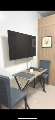 a dining room table with two chairs and a tv at Pasay Manila Condominium Rentals, walking distance to Mall of Asia and near in Manila airport, located in Shore Residences Seaside Boulevard in Manila