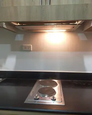 a stove top oven with a light above it at Pasay Manila Condominium Rentals, walking distance to Mall of Asia and near in Manila airport, located in Shore Residences Seaside Boulevard in Manila