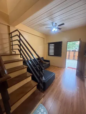 a living room with a staircase in a house at Apt101 Guest House in Bacoor
