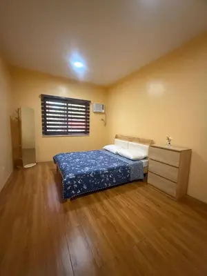 a bedroom with a bed and a dresser and a window at Apt101 Guest House in Bacoor