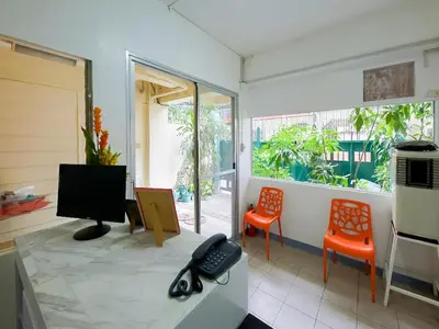 a room with a desk with a television and two chairs at Orangenest Apartelle in Sampong