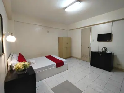 a hotel room with a bed and a television at Orangenest Apartelle in Sampong