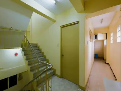 a hallway with stairs and a door in a building at Orangenest Apartelle in Sampong