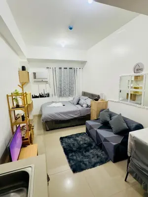a large living room with a bed and a couch at Ellain's Cozy Staycation-SMDC Green 2 Residences in Dasmariñas
